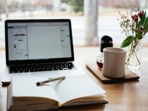 Laptop computer with notebook on the pros and cons of BA Insight vs Glean