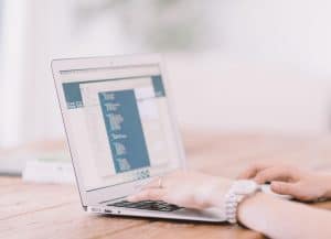 Businesswoman typing on a laptop and reviewing BA Insight vs Glean comparison